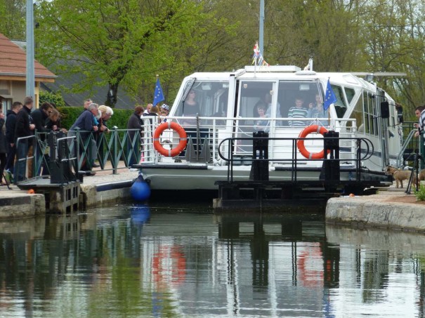 Boats are raised up in a lock by the bridge.